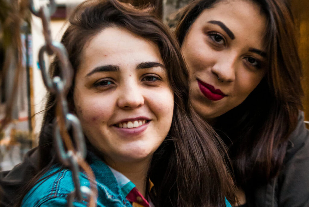 Mother with teenage daughter smiling together.