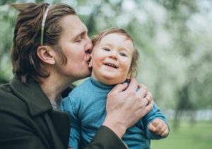 Father kissing son.