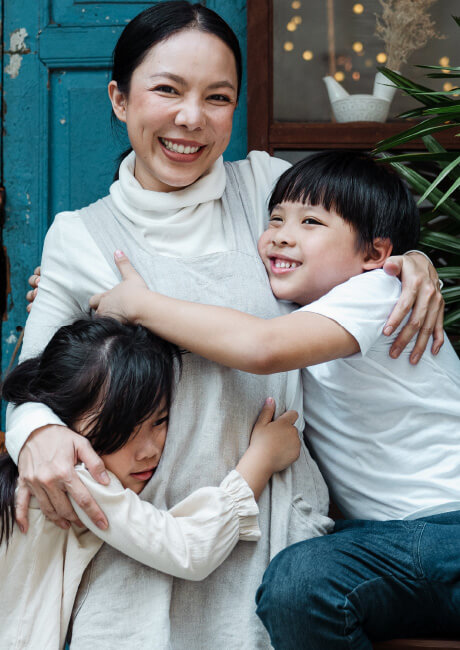 Woman with two children hugging her.