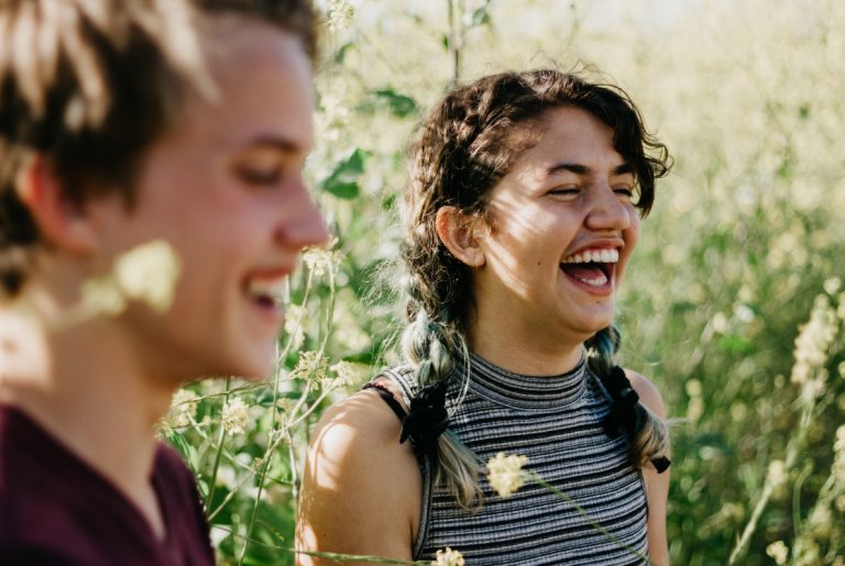 Two teenagers laughing together.