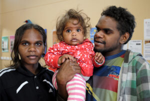 Parents with child looking to camera.