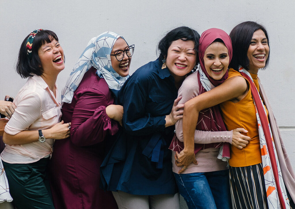 Group of women smiling and standing in a line