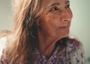 Lady with painted flowers on her face smiling. 