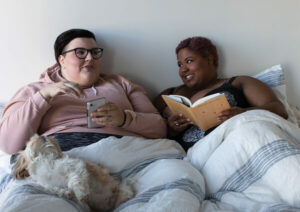 Two people reading in bed together.