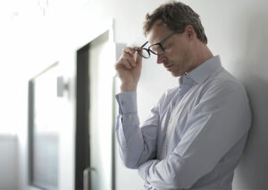 Man with hand to head in exhaustion.