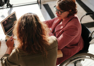 Person in wheelchair speaking with staff.