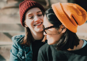 Two women talking together smiling.