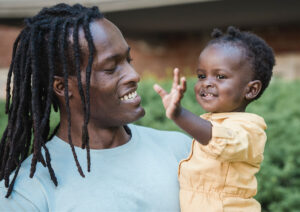 Father holding daughter up laughing together.