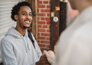 Man smiling greeting another person.