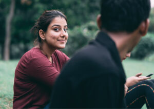 Girl smiling at camera with other people around.