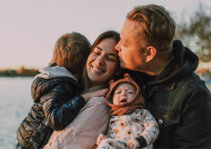 A family hugged tightly together with soft afternoon light.