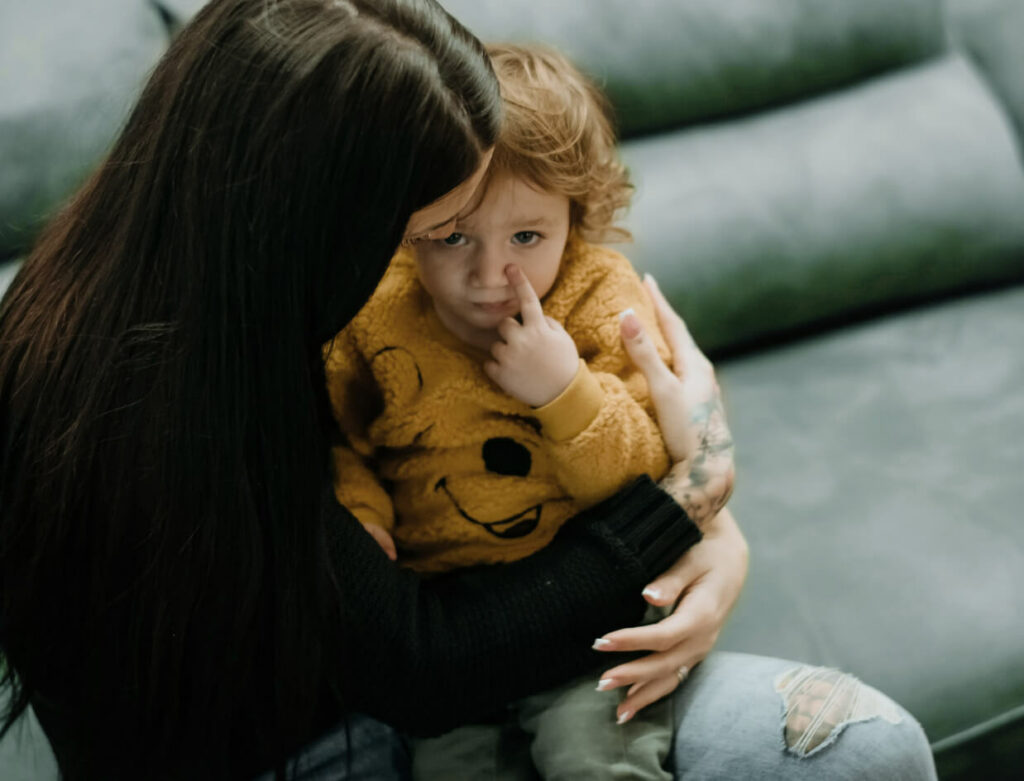 Mother holding upset child.