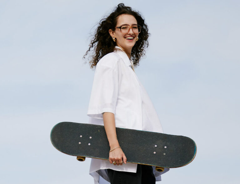 Young person holding a skateboard.