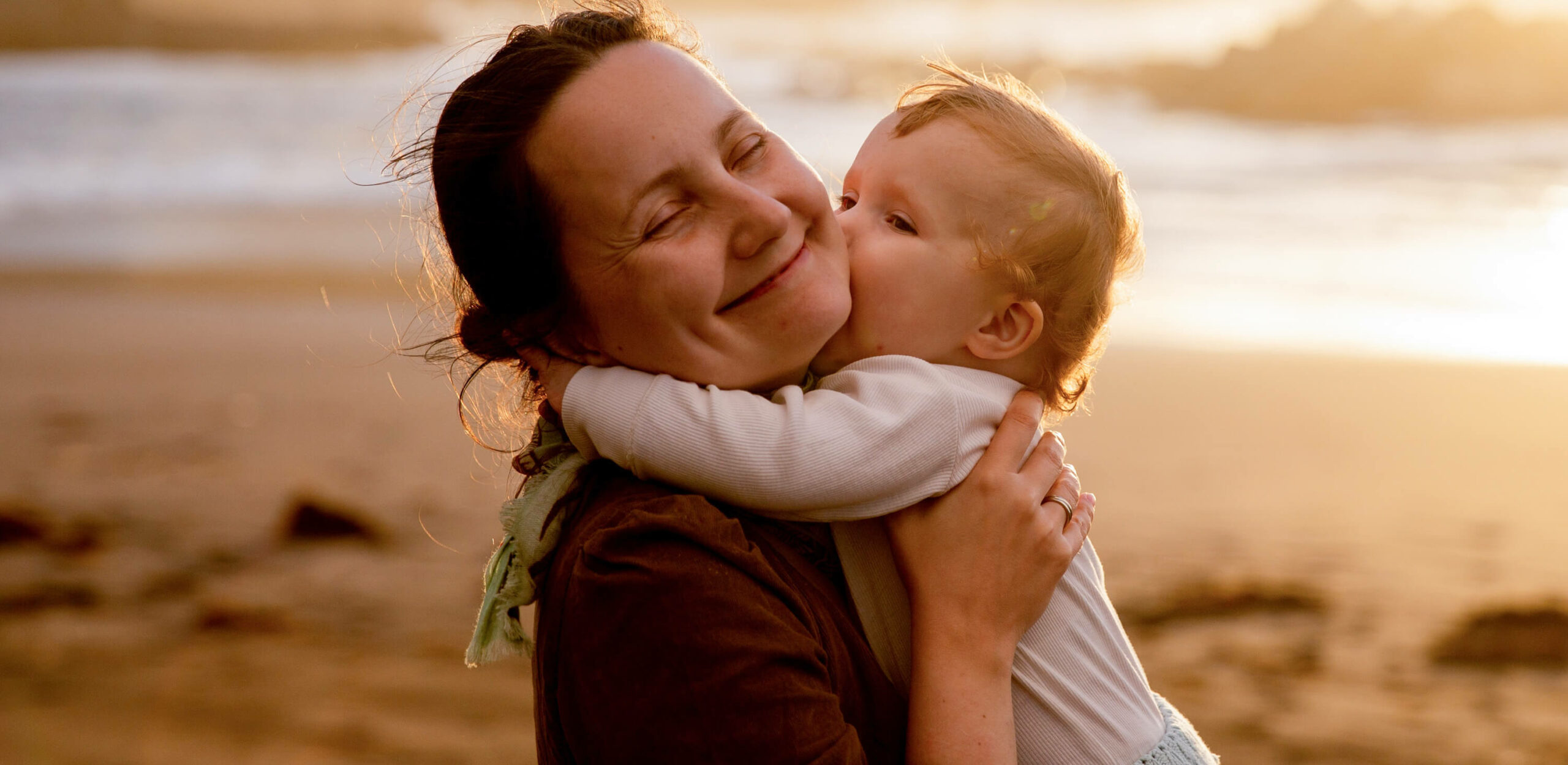 http://Mother%20holding%20their%20baby%20at%20the%20beach.